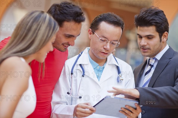 Hispanic people and doctor using tablet computer in gym