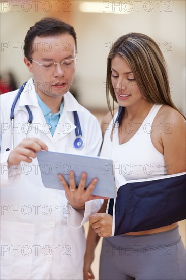 Hispanic doctor and patient using tablet computer
