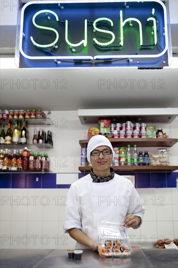 Mixed race chef working in sushi bar