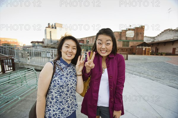 Chinese mother and daughter making peace sign