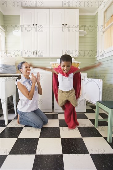 Mixed race mother and son playing with laundry