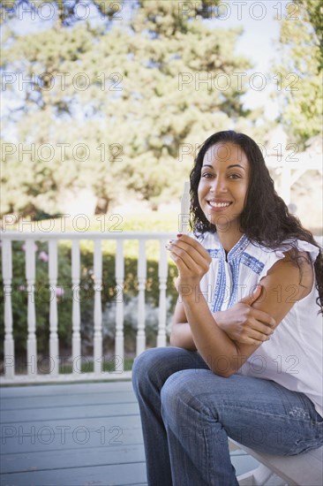 Mixed race woman holding pregnancy test