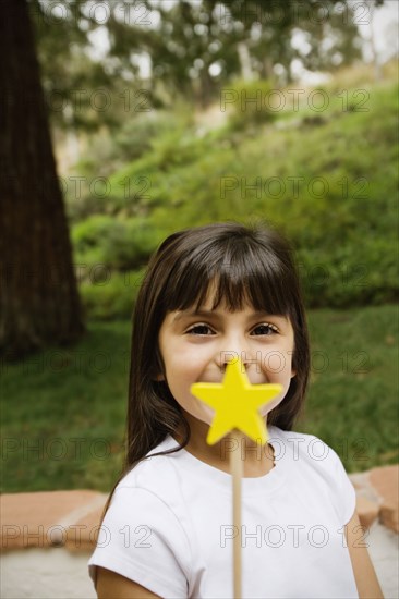 Mixed race girl holding star wand