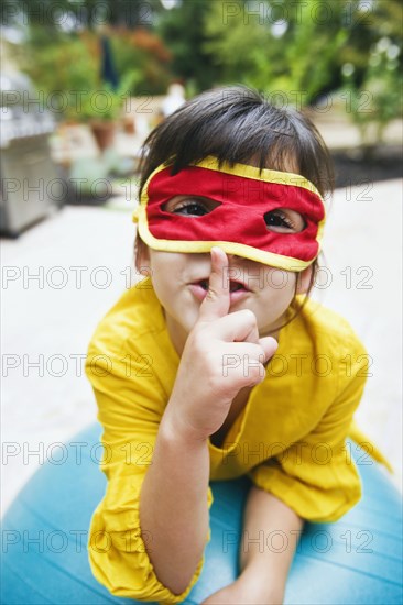 Mixed race girl wearing mask and gesturing