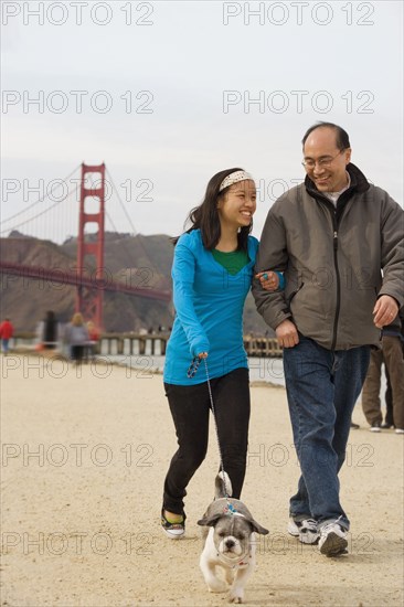 Chinese father and daughter walking dog