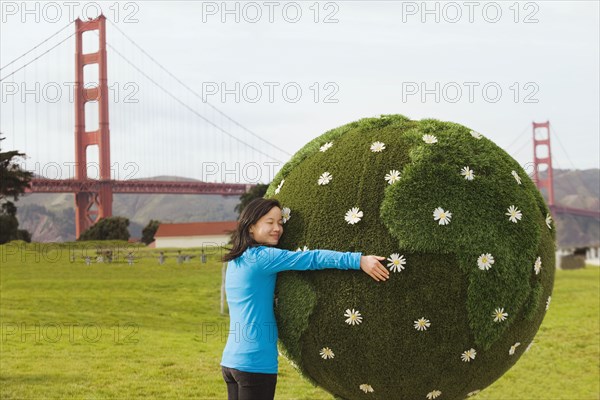 Chinese girl hugging earth topiary