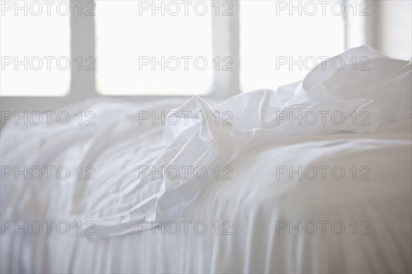 Close up of white sheets on bed