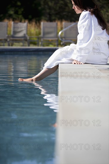 Woman soaking feet in swimming pool