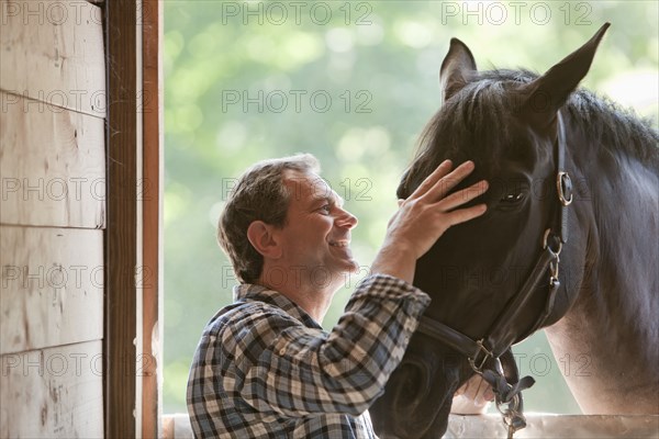 Caucasian man petting horse