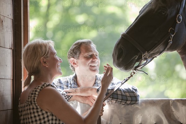 Caucasian couple watching horse