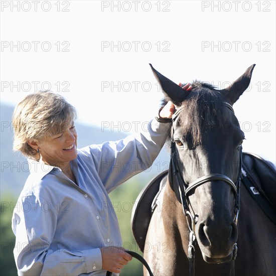 Caucasian woman petting horse