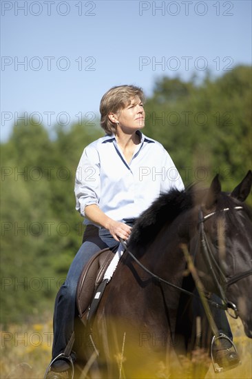 Caucasian woman riding horse