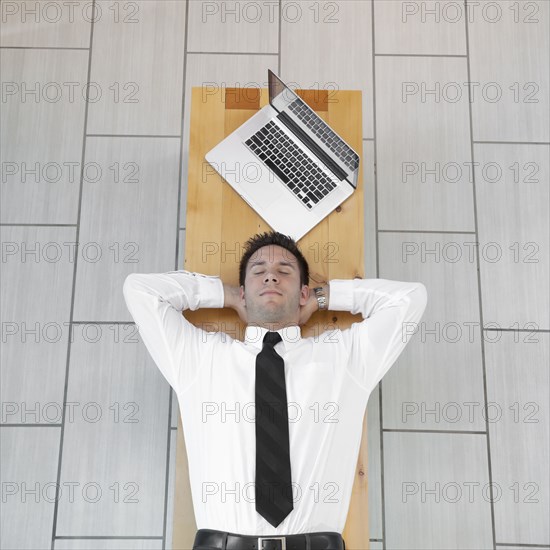 Caucasian businessman sleeping on bench