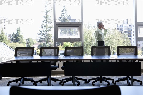 Caucasian businesswoman using cell phone in conference room