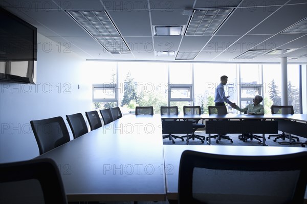 Business people shaking hands in conference room