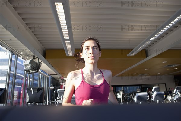 Woman running on treadmill in health club