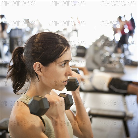 Woman lifting weights in health club