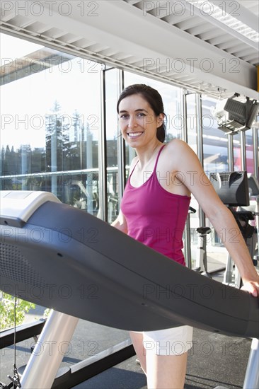 Smiling woman on treadmill in health club
