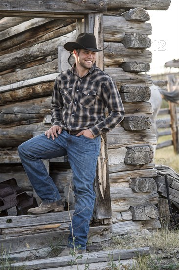 Caucasian cowboy leaning in doorway of cabin