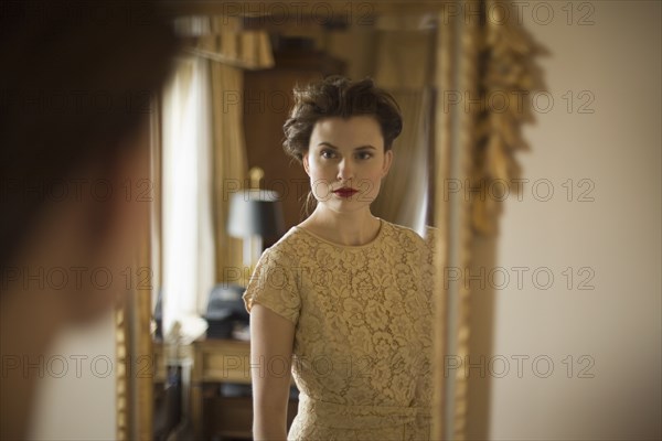 Woman wearing fancy dress looking in mirror