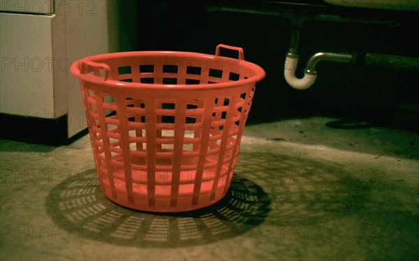 Empty laundry basket on floor in basement