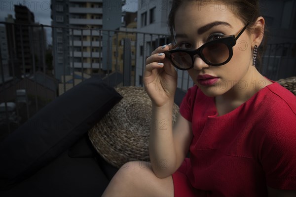 Caucasian woman peering over sunglasses