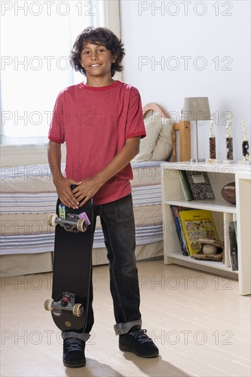 Mixed Race boy holding skateboard