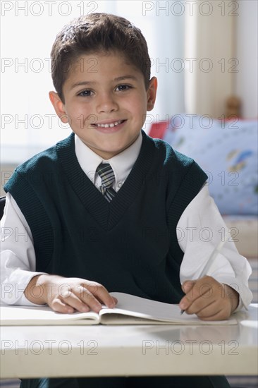 Hispanic boy writing in notebook