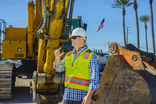 Caucasian construction worker using walkie-talkie