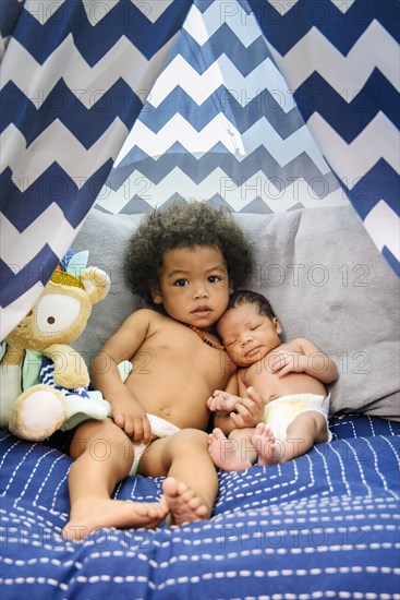 Mixed Race baby boys cuddling on bed
