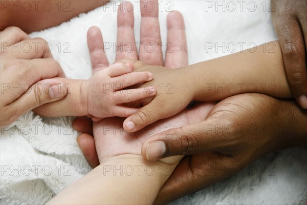 Intertwined hands of Mixed Race family