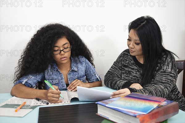 Mother helping daughter with homework