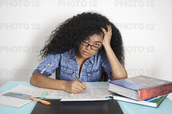 Frustrated Mixed Race teenage girl doing homework