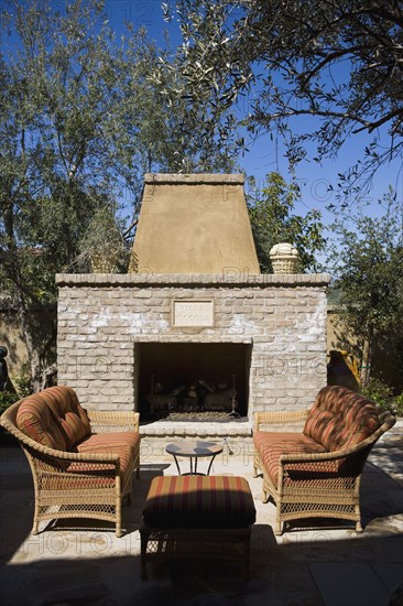 Outdoor sitting area with sofas near stone fireplace