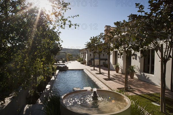 Backyard with fountain leading into swimming pool