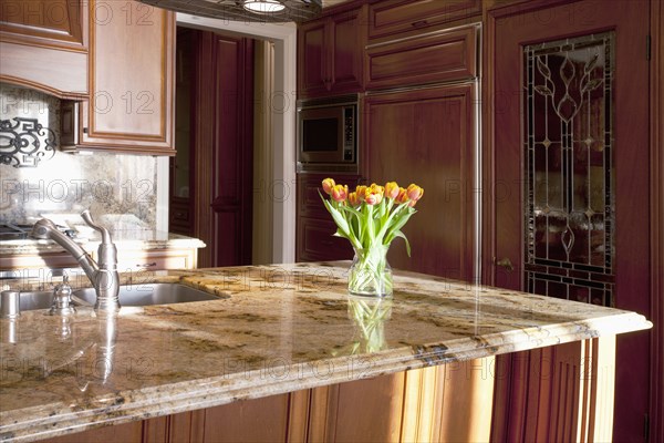 Vase of tulips on kitchen countertop