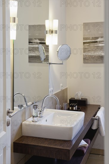 Sink on wooden countertop in domestic bathroom