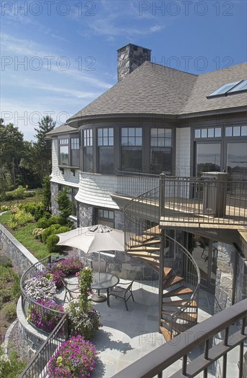 Exterior of a single family home with spiral staircase leading to yard