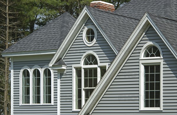 Window with shingled roof in single family home