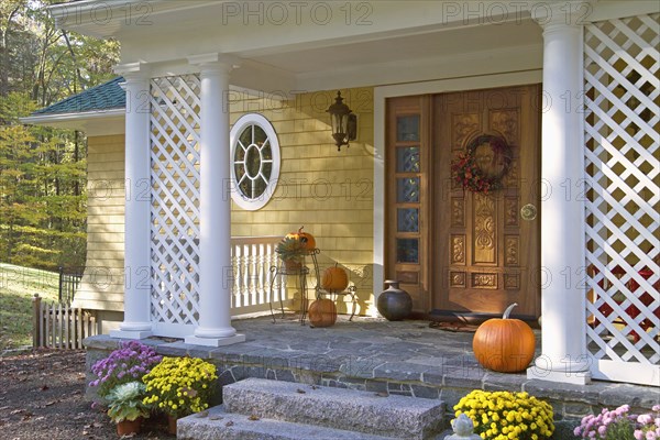 Pumpkins and flower pots at front door of single family home
