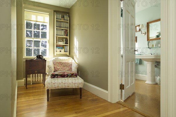 Long armchair on hardwood floor in traditional clean home