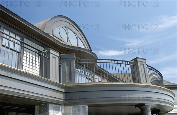 Exterior of home with round top window and balcony