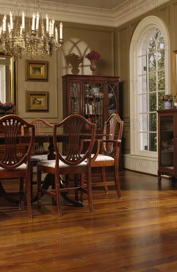 Elegant dining room with oak hardwood floors and hepplewhite style dining chairs