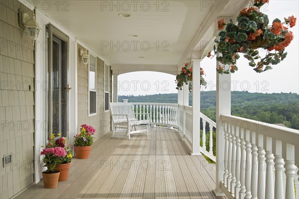Large front porch of shingle style home with great view of tree tops