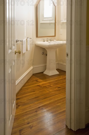 View into small bathroom with pedestal sink