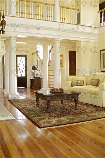 Traditional living room with support columns and loft with railing