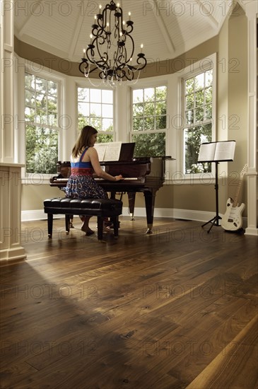 Young woman playing a grand piano