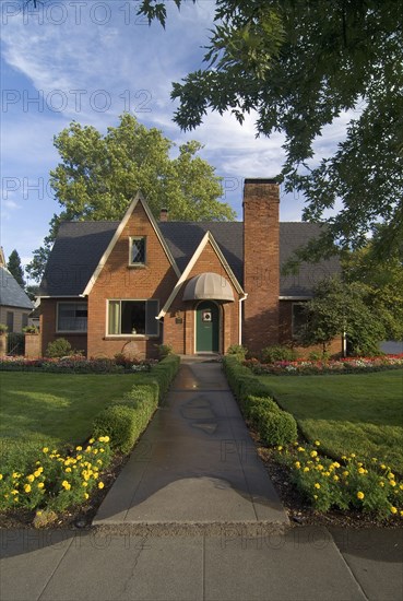 Exterior front view of red brick cottage with landscaping at Chico