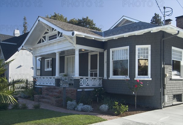 Front exterior view of a blue bungalow with white trim