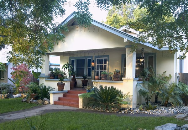 Front exterior yellow bungalow with green trim